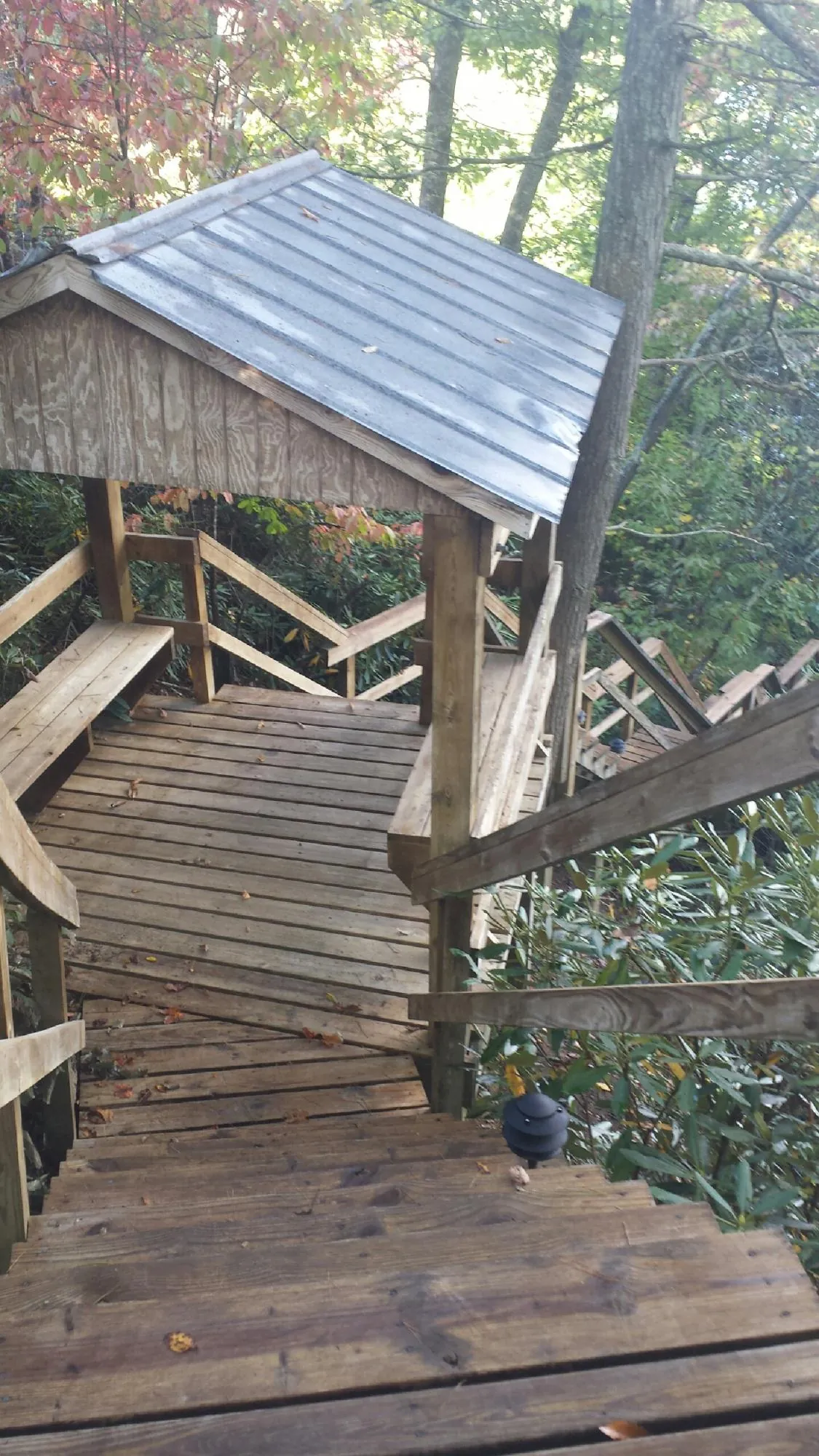 Metal roofed shelter over wooden steps on a wooded walkway — Skylight Repair & Installation work by our crew in Fox Lake